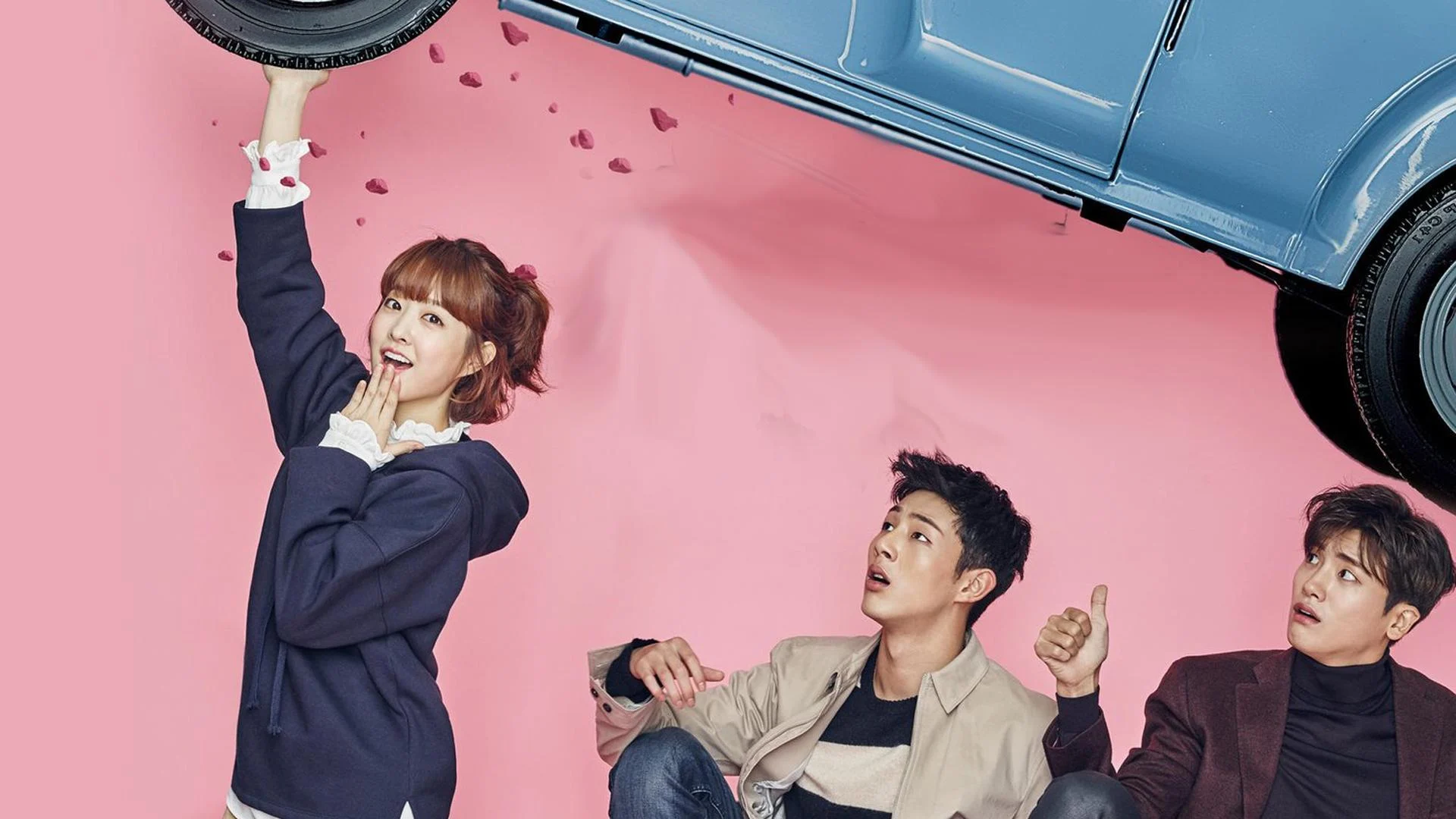 A woman happily holding a car up while a man on the ground looks at her in awe