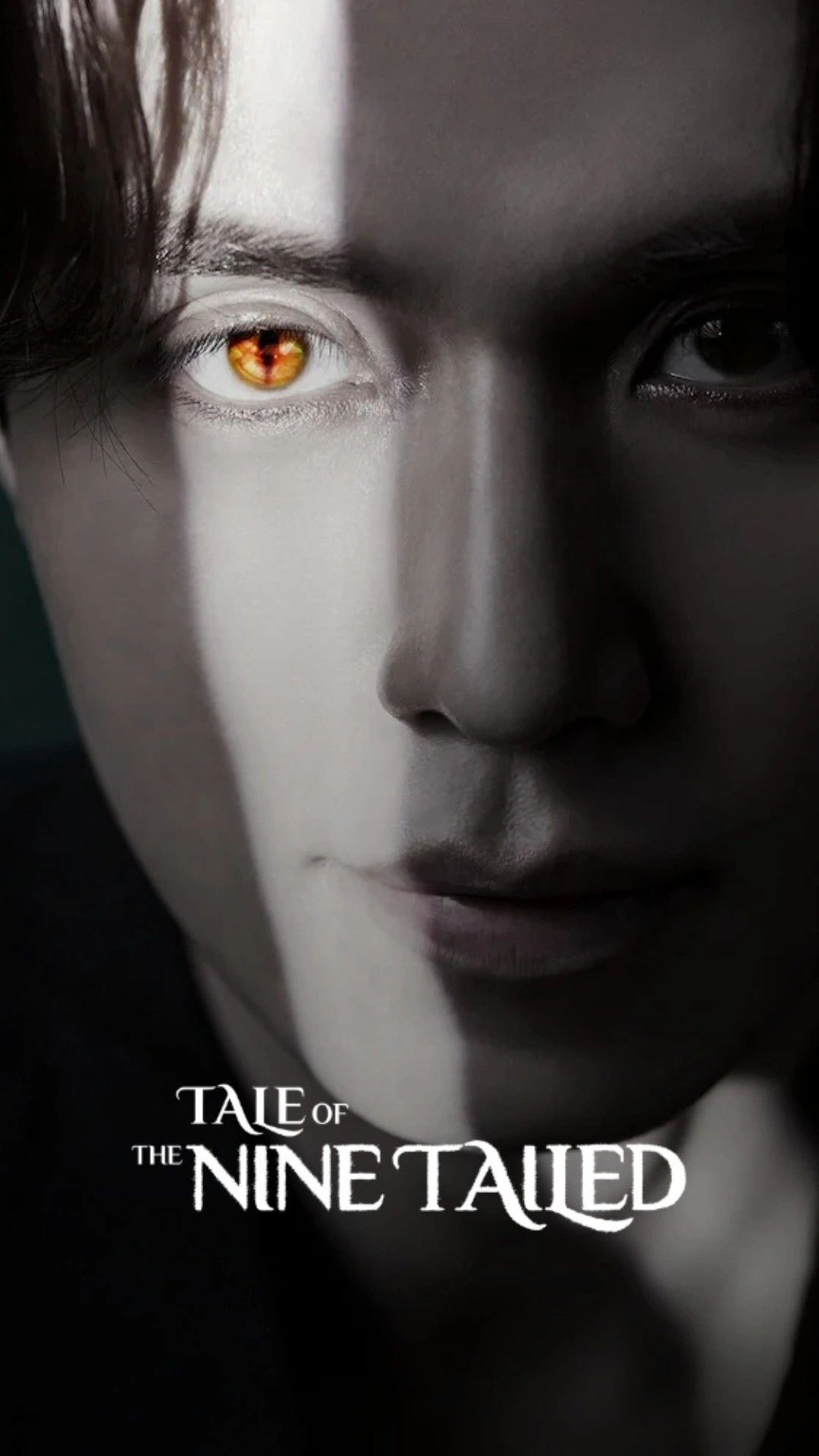 A close-up of a man's eye glowing gold with a snake-like pupil