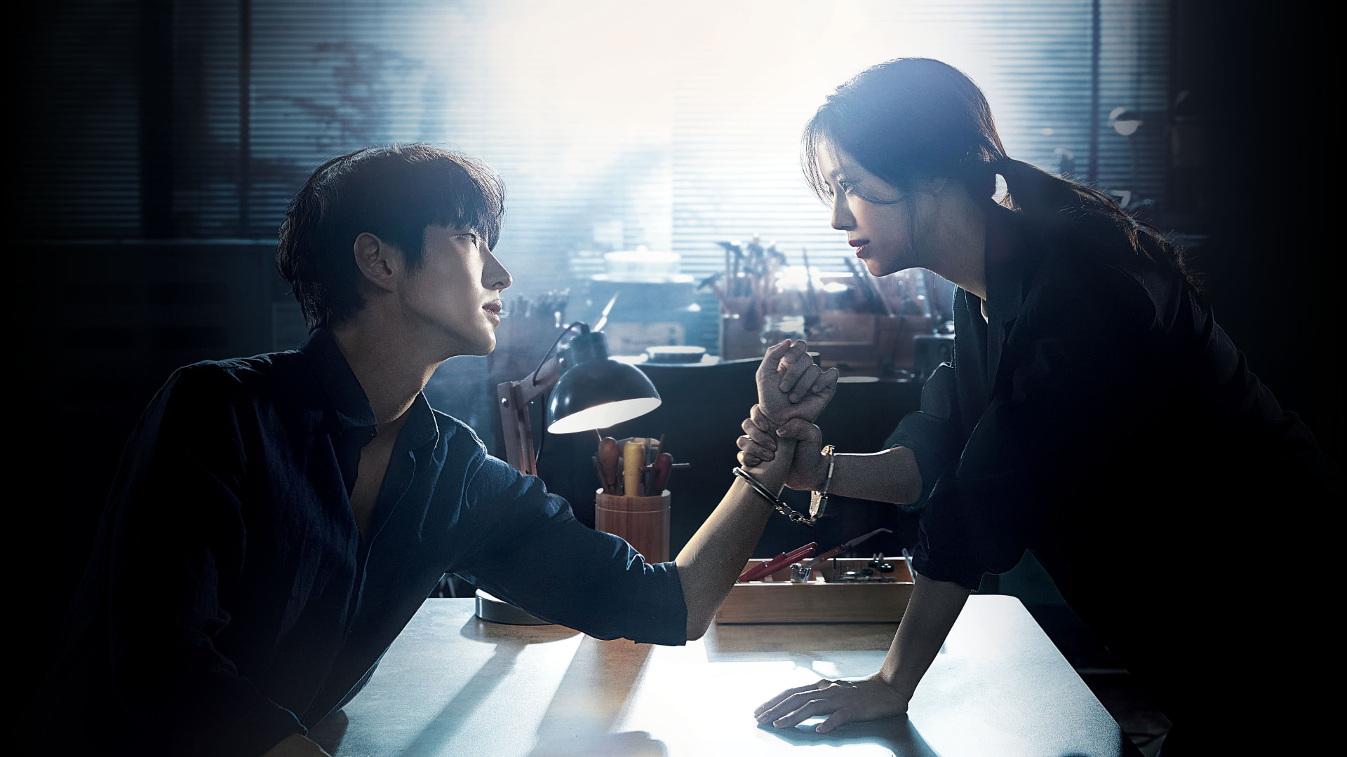 A man and woman staring intensely at each other in a suspenseful scene